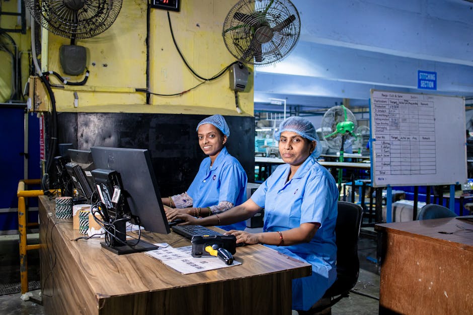 Indian blue-collar textile workers using computers in a factory setting.
