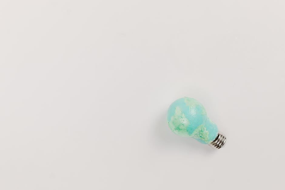 Artistic concept of earth as a lightbulb on a minimalist white background.