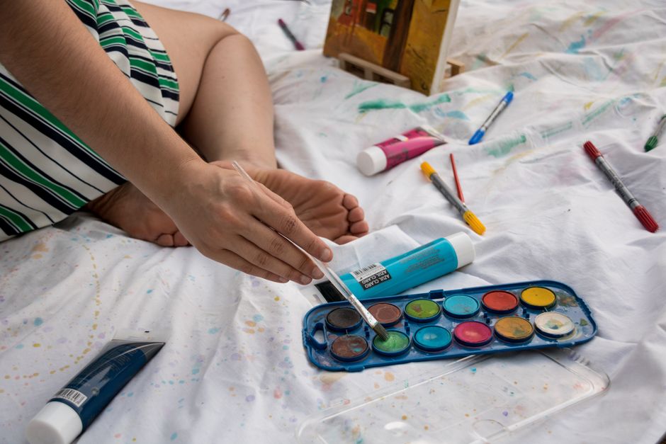 An artist's hand blends vibrant watercolors during a relaxing indoor painting session.